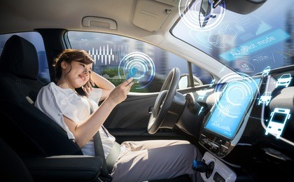 woman using smart phone in autonomous car. self driving vehicle. driverless car. autopilot. automotive technology.