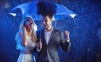 attractive couple under umbrella walking at night 