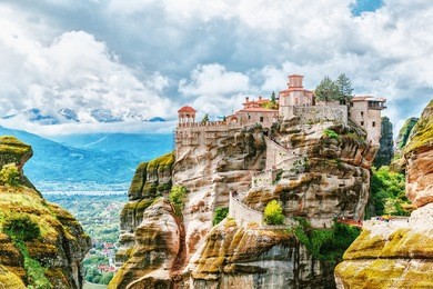monastery meteora greece. stunning summer panoramic landscape. view at mountains and green forest against epic blue sky with clouds. unesco heritage list object.