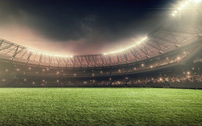 soccer stadium with illumination, green grass and night sky
