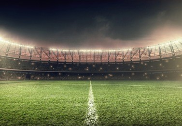 soccer field with illumination, green grass and night sky