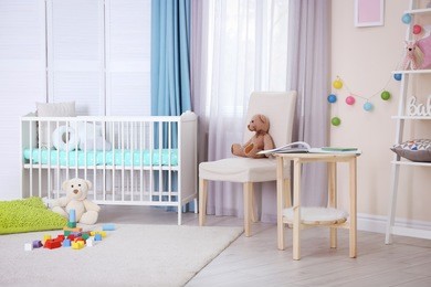 interior of light cozy baby room with crib and bedding