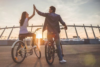 beautiful romantic couple is having rest in the city with bicycles on the sunset. enjoying the company of each other.