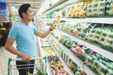 asian man choosing paper in supermarket