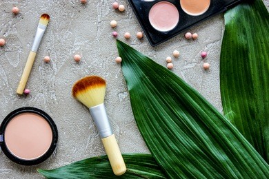 pastel set of decorative cosmetics with brushes on stone woman desk background top view pattern