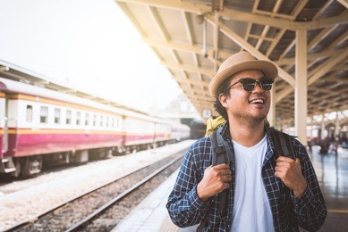 young asian traveler backpack in train station