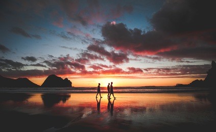 sunset at piha beach, new zealand
