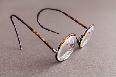 old fashion design spectacles eyeglasses on gray paper background. vintage style men fashion accessories. macro view, shallow depth of field, soft focus.
