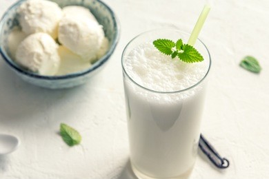 vanilla shake with ice cream and mint on white background. vanilla ice cream milk shake. banana smoothie with mint and vanilla.