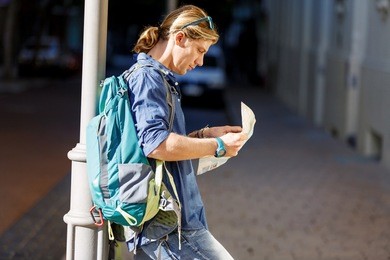tourist with backpack in the town holding a map