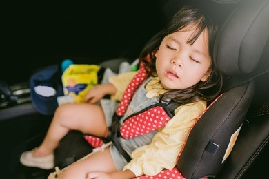 transport, safety, childhood road trip and people concept - happy little girl sleeping in baby car seat, child in auto baby seat in car, adorable little girl in the car.