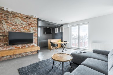 living room with industrial brick wall and gray sofa