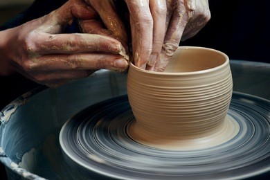 master class on modeling of clay on a potter's wheel in the pottery workshop