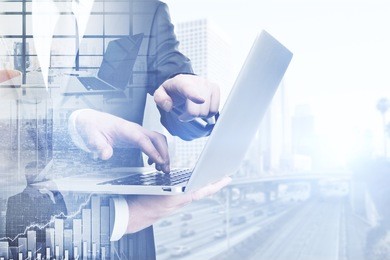 side view of businessmen using laptop on abstract city background. meeting concept. double exposure