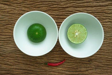 cut lemon in white bowls and chili set up as smiling face use as spicy concept
