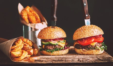  mouth-watering, delicious homemade burger used to chop beef. on the wooden table. the burgers are inserted knives.