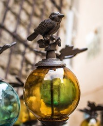bird on a glass bowl, decor for a garden. market in provence, france. close-up.