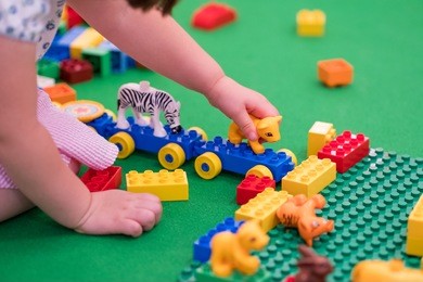 young kid playing with colorful bricks.
