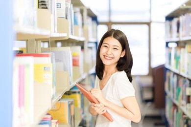 asian lady student finding a book in the library