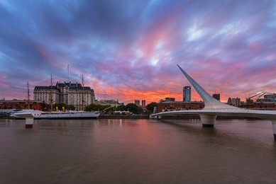 women's bridge and historic fragata sarmiento after sunset. puerto madero, buenos aires, argentina.