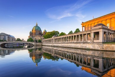 berlin cathedral (berliner dom) reflected in spree river at dawn, germany