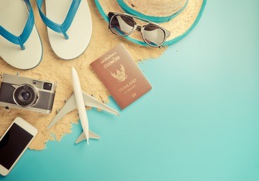 summer travel accessories on sand beach with blue copy space.