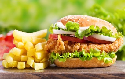 chicken burger with french fries on a wooden table