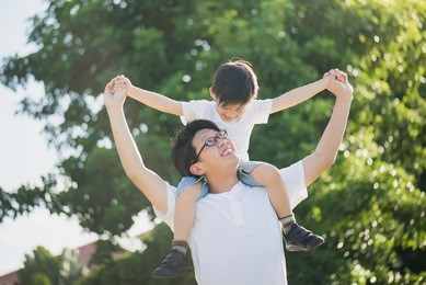 asian father and son playing in the park