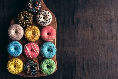 glazed mini donuts on wooden background with blank space 