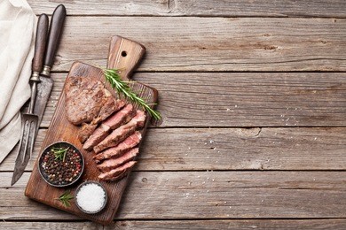 grilled beef steak with spices on cutting board. top view with copy space