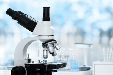 laboratory lens of microscope isolated on bokeh/blur light blue scientific research background
