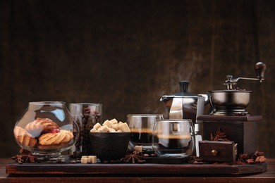cup of coffee and coffee ingredients on wooden table  with cinnamon and anise stars.