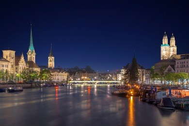 panoramic view of historic zurich city center with famous fraumunster church and river limmat at lake zurich , in twilight, canton of zurich, switzerland