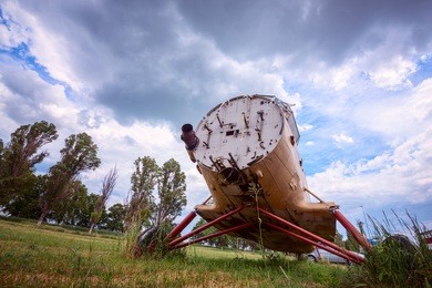 old abandoned plane on a overgrown aerodrome, under low floating clouds. wide angle of shooting.