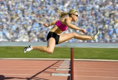 female track and field athlete hurdling.
