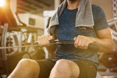 athletic man using rowing machine in the gym.