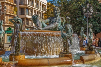 turia fountain with bronze statue of the roman god neptune in valencia, spain