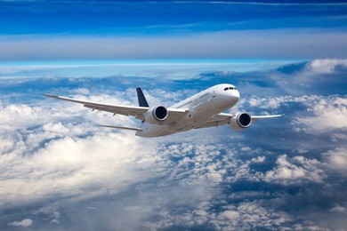 passenger wide-body airplane in flight. aircraft flies high in the sky above the clouds. front view.