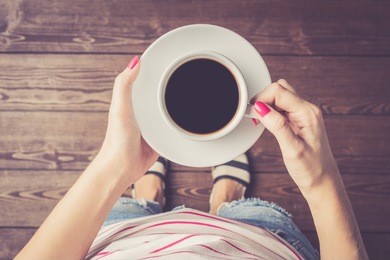 woman holding cup of coffee. top view
