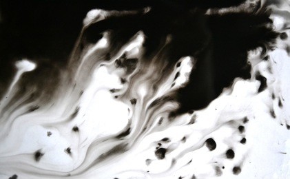 black ink conveyed over white close-up paper. abstract background isolated on white background. ink stains spread out and absorbed into the paper macro.