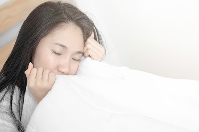 asian girl in bed. lazy to get up wake up in the morning