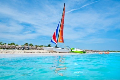 the beautiful beach of varadero in cuba with a colorful sailboat and turquoise water