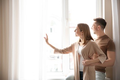 happy couple looking out plastic window