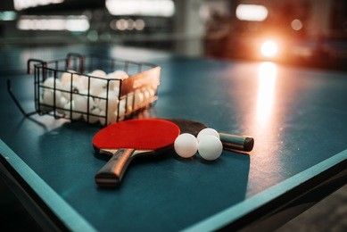ping pong table, rackets and balls in a sport hall