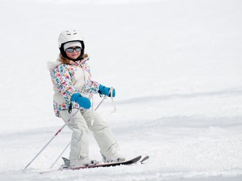 little girl skiing downhill -  ( space for text)