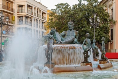 turia fountain with bronze statue of the roman god neptune in valencia, spain