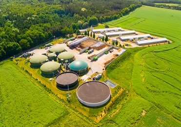 aerial view over biogas plant and farm in green fields. renewable energy from biomass. modern agriculture in czech republic and european union. 