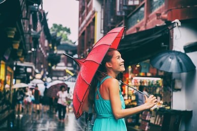 people lifestyle umbrella travel asian woman shopping in chinatown market street. rainy day girl tourist under red oriental umbrella in back alleys in shanghai, china.