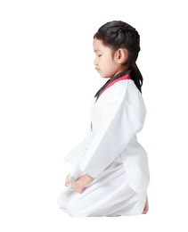 asian little girl is sitting for concentration in taekwondo uniform isolated on white background, with clipping path