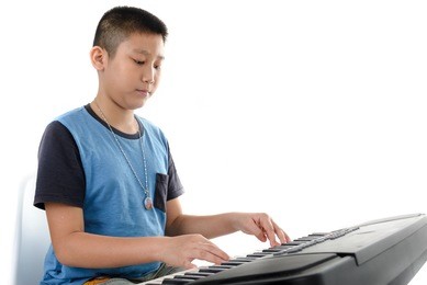 asian boy playing keyboard music  on white background